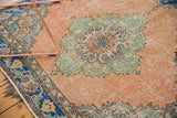 Distressed Oushak rug runner showing a faded peach field, mint medallion, and blue border.