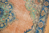 Distressed Oushak rug runner segment, blush field, blue medallion, green accents, and visible wear.