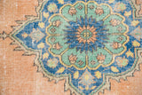 Distressed vintage Oushak runner with mint green medallion and wear on peach ground.