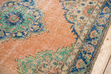 Distressed blush field with deep blue, mint green Oushak rug medallion detail.