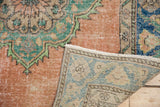 Distressed vintage Oushak rug runner detail showing blush pile with mint green motifs and hand-knotted backside.