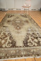 Distressed Oushak runner showcasing worn beige, sand, and chocolate brown medallion and spandrels.