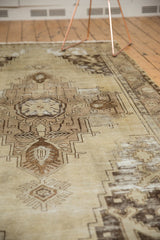 Distressed rectilinear and scrolling patterns on this vintage Oushak rug.