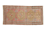 Distressed vintage Oushak runner with faded geometric medallions in cinnabar red, silver, and sage.