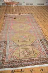 Distressed geometric patterns and pinwheel color fills on the vintage Oushak runner's end.