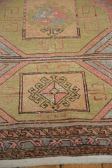 Geometric pinwheel gul detail in sage green, blush, and silver on distressed Oushak rug.