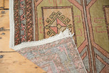 Distressed vintage Oushak runner: geometric guls, soft colors, and visible hand-knotted foundation.