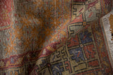 Distressed Turkish Oushak rug corner detail: faded royal blue, red motifs, and fringe.