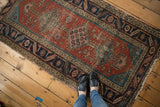 Antique Heriz rug runner with dark madder root red field, aqua blue spandrels, and evident wear.