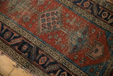 Antique Heriz rug with madder red field, aqua blue serrated spandrel, navy border, showing even wear.