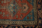 Heriz rug runner detail: madder root red field, aqua spandrel with serrated contour, geometric border, visible wear.
