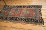 Antique Persian Heriz rug runner end with hard tatter and loss, showing madder root red and aqua blue.