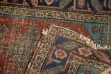 Antique Heriz runner, showing worn pile, visible foundation, and tattered fringe.