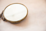 Detail of antique beveled glass shaving mirror, showing darkened patina on accordion arm.