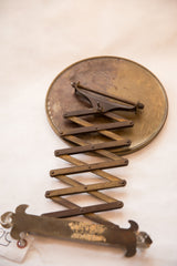 Darkened patina on the antique accordion mechanism and fleur de lis hardware.