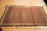 Antique Belouch rug featuring madder root red boteh field, historic wear, and worn edges.