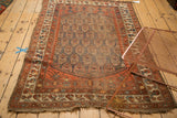 Antique Northwest Persian rug's tattered lower left corner, madder red field, and discoloration.