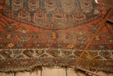 Tattered edge of a Northwest Persian rug, with exposed knot heads and madder red field.
