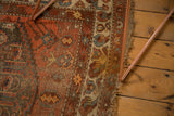 Antique Northwest Persian rug's tattered end, madder root red field, and ivory border.
