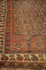 Storied texture of antique Northwest Persian rug, revealing madder red and navy floral boteh patterns.