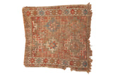 Antique Caucasian rug fragment featuring geometric starbursts, red, blue, and brown tones.