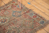 Antique Caucasian fragment rug with prominent geometric starbursts, exposed foundation, tattered fringe.
