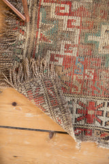 Antique Caucasian fragment showing heavy wear, exposed foundation, and tattered fringe.
