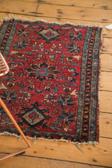 Antique Lilihan rug, cherry red field with stylized floral motifs, and visible tattered end fringe.
