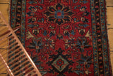 Cherry red field of the antique Lilihan rug, displaying a floral diamond motif.