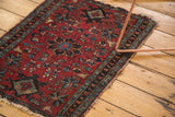 Antique Lilihan rug featuring intricate floral patterns, cherry red field, and tattered side.