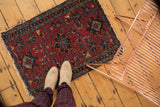 Lilihan rug's cherry red field with teal, navy floral motifs, visible tattered end.