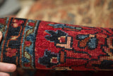 Rich cherry red and navy blue in the dense hand-knotted pile of an antique Lilihan rug.