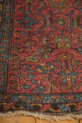 Vintage Lilihan rug corner: raspberry red field with serrated leaves, sky blue border, tattered fringe.
