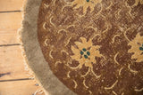 Peking round rug edge, revealing worn pile, faded gold florals, ocean green, and tendrils.
