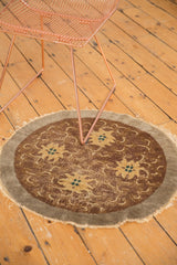 Antique Peking rug's worn camel grey field, dusty gold flowers with ocean green blue, and tattered edge.