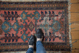 Antique Lilihan rug, blush field with blue germinating plant motifs, intricate vine border, visible wear.