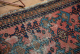 Antique Lilihan rug: germinating plant motifs, meandering vine border, dusty blush, sky blue, navy, worn.