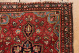 Vintage Farahan Sarouk rug corner with intricate cherry red floral field and layered botanical borders.