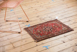 Angled vintage Farahan Sarouk rug, displaying cherry red field and detailed floral medallions.
