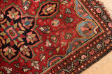 Intricate floral tendrils and outlining in sky blue and cherry red along the Farahan Sarouk border.