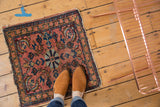 Antique Lilihan rug’s bold center roundel with dusty rose and navy floral petals.