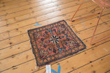 Antique Lilihan square rug showcasing its pale dusty rose floral center, intricate vinery, and worn borders.