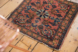 Antique Lilihan Persian rug corner with intricate dusty rose and blue floral borders and worn fringe.