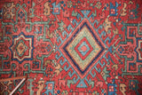 Antique Karaja rug's traditional geometric medallion, cherry red, sky blue, and mallard green, with wear to knot heads.