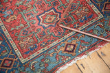 Antique Karaja rug corner detail: cherry red geometric motifs, aqua border, and tattered fringe.
