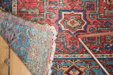 Antique Karaja rug folded to show its hand-knotted foundation and richly patterned pile.