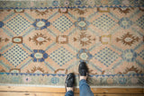 Textured distressed Oushak runner with pale blush, bronze, and faded blue lattice design.