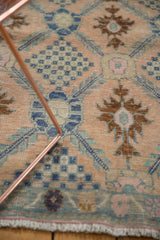 Faded blush distressed Oushak runner detail: blue lattice, checkered bouquets, and fringe.