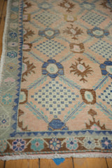 Distressed Oushak rug's textured pile, border, and fringe with faded blush, blue, bronze motifs.