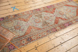Distressed vintage Oushak runner with stepped serrated medallion, antique ivory, rust, pink tones.